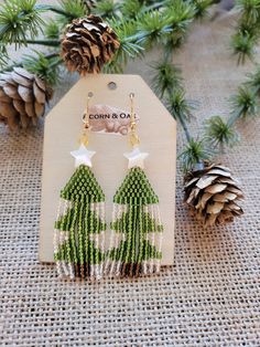 green and white beaded christmas tree earrings with gold tone hooks on a burlap background