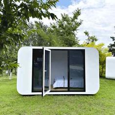 a small white building sitting on top of a lush green field