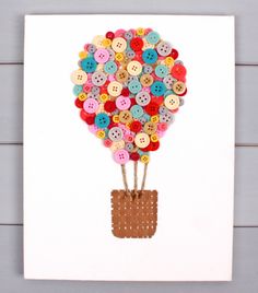 a card with buttons attached to it and a hot air balloon in the middle, on a white background