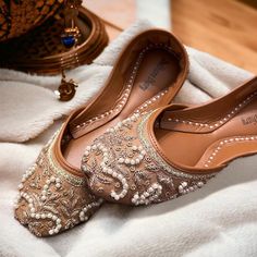 Introducing our exquisite Bronze Bridal Khussa, a true masterpiece crafted to enhance your special day with elegance and comfort. Meticulously handcrafted with genuine leather and adorned with high-quality silk, these Khussa shoes are the epitome of luxury and style. Each pair is a testament to the artistry of our skilled artisans, featuring intricate cora and beadwork that adds a touch of regal charm. But beauty is not the only aspect we've considered; we've prioritized your comfort as well. Th Bridal Khussa, Bridal Flat Shoes, Bridal Flats, Bridal Shoes Flats, Womens Wedding Shoes, Sun Kissed, Bridal Looks, Bridal Shoes, Flat Shoes