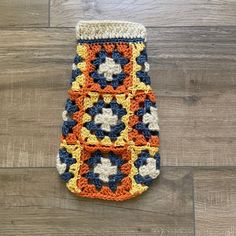 a crocheted pot holder is sitting on the floor next to a wood floor