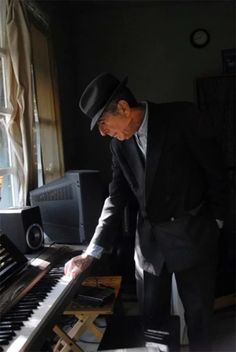 a man in a suit and top hat playing the piano