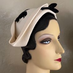 This Is An Amazing Sample Of The High Fashion Millinery Creations Of The Elegant 1950s'! This Asymmetrical Cap Is Made Of A Stiff Material Covered In A Beautiful Off White Colored Honeycomb Textured Fabric. The Cap Is Surrounded By Very Creative Folds As Shown In The Photos, Ending In A Point At One Side. The Top Of The Cap Is Trimmed With Black Curly Feathers, And The Front Has A Velour Covered Wire Made To Look Like A Twig, Ending Two Bulb Shapes Plus A Pearl At Each End. Throughout The 1950s, Ladies Wore Hats Daily As A Part Of Their Attire As Was A Pair Of Gloves. Post War 1940’s And 1950’s Saw Many Women Choosing Not To Wear Hats On A Regular Basis. To Preserve Its Market, The Mil Cream Cloche Hat For Evening, Fitted Cream Hat For Vintage Events, Classic Fitted Cream Cloche Hat, Cream Cloche Hat For Kentucky Derby Evening, Cream Brimmed Cloche Hat For Evening, Elegant Kentucky Derby Hat For Vintage Fashion, Retro Fitted Cream Hat, Fitted Retro Cream Hat, White Fitted Retro Hat