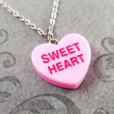 "This listing is for a pink sweetheart candy heart charm necklace. You'll be able to choose your chain length and style at checkout by using the \"Chain Length/Style\" drop-down menu. Keyrings, bangle bracelets, ball chains, and black/brown leather and suede cord are also available. **Please see the second photo for scale! If you're on the mobile site, just swipe to the side. :) ITEM CARE: Avoid contact with water, for best results. - - - - - - - Sign up for our newsletter to receive coupons and updates on new items! Follow the link: ♦ ♦ ♦ http://eepurl.com/cG7GGT ♦ ♦ ♦ - - - - - - - This is our third shop for jewelry. If you're looking for something a bit more \"personalized\", then just follow these links: www.etsy.com/shop/metalspeak www.etsy.com/shop/metalspeaktoo - - - - - - - Thank y Pink Kawaii Jewelry For Valentine's Day, Kawaii Pink Jewelry For Valentine's Day, Sweet Pink Necklaces For Valentine's Day, Sweet Pink Necklace For Valentine's Day, Trendy Nickel-free Pink Charm Necklace, Pink Novelty Jewelry For Valentine's Day, Pink Heart Pendant Charm Necklace For Mother's Day, Personalized Pink Charm Necklace As Gift, Cute Heart Charm Necklace For Gifts