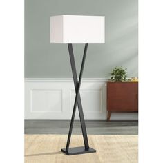 a floor lamp with a white square shade on the top and a black metal base