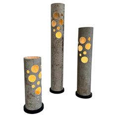 three cement vases with gold dots on them are shown in front of a white background