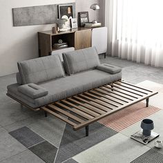 a living room with a couch, coffee table and rugs on the floor in front of a window