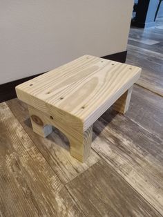 a wooden bench sitting on top of a hard wood floor