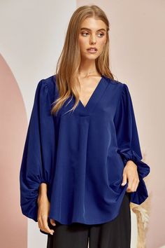 Blue is the color of the sky and sea, and in this blouse it’s the color of confidence. With a flowing silhouette and 3⁄4 sleeves that billow with carefree spirit, the Be Yourself top invites you to embrace your true self. Made for turning heads with every flutter of its fluid bodice, this ravishing royal blue top is a sartorial reminder that style knows no limits. Pair it with white denim for a nautical vibe or a boldly printed bottoms to really make a statement. However you style it, one thing’ Blue Blouse With Balloon Sleeves For Work, Solid Color Lantern Sleeve Blouse For Brunch, Flowy Blouse With Blouson Balloon Sleeves, Elegant Blue Blouse With Pleated Sleeves, Summer Billowy Blue Top, Billowy Blue Summer Top, Blue Tops With Blouson Sleeves For Brunch, Billowy Blue Top For Summer, Blue Blouson Sleeve Tops For Brunch