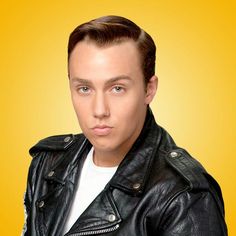 a man in a black leather jacket is posing for a photo on a yellow background