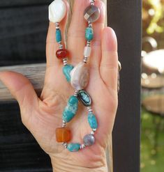 As an art lover, you'll appreciate this handcrafted treasure necklace by a Santo Domingo Native American artisan. The earthy, multi-stone design, adorned with stunning beads and seashells, is a one-of-a-kind piece that will become your signature piece. Its vibrant semi-precious stones and shiny shells make it a true statement. Length: 28 1/2" cannot be extended Weight: 59 grams Vintage never worn Artisan Necklace With Amazonite Gemstone Beads, Artisan Amazonite Round Bead Necklace, Turquoise Gemstone Long Beaded Necklace, Artisan Necklace With Natural Stones And Amazonite, Handmade Southwestern Necklace For Beach, Bohemian Turquoise Agate Jewelry, Turquoise Agate Beaded Necklace, Turquoise Agate Beaded Necklace With Gemstones, Turquoise Agate Gemstone Beaded Necklaces