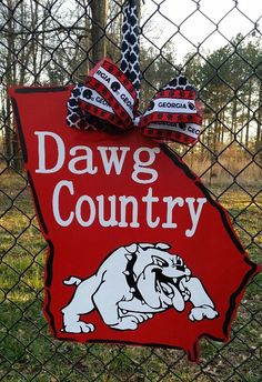 a red sign that says dawg country with a dog on it and a bow