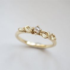 a gold ring with three leaves and a diamond