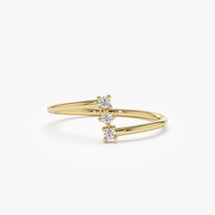 a yellow gold ring with two diamonds on the top and bottom, set against a white background