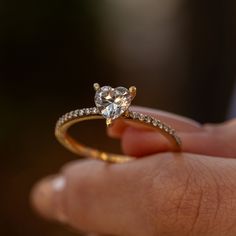 a close up of a person holding a ring with a diamond on the top and side