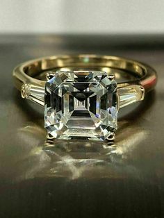 an emerald cut diamond ring with two baguets