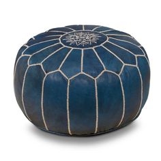 a blue leather poufce with white stitching on the bottom and an intricate design