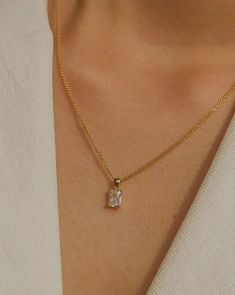 Simple, graceful, and minimalistic, this piece features a rectangular clear crystal CZ stone suspended on the daintiest gold chain. Made with 100% gold-filled materials, she is truly an everyday necklace that you can wear whenever and wherever your heard desires — even in the shower. …………………………………. D E T A I L S • Pendant measures 5 x 13 mm • Tarnish-resistant, waterproof, safe for sensitive skin • 1.5mm width curb chain with spring clasp • 100% 18k gold-filled White Minimalist Necklace For Everyday Elegance, Minimalist White Necklace For Everyday Elegance, Elegant Charm Necklace With Delicate Chain For Everyday, Elegant Everyday Pendant Charm Necklaces, Elegant Everyday Charm Necklaces, Minimalist Jewelry With Square Pendant And Adjustable Chain, Modern Jewelry With Clavicle Chain And Square Pendant, Everyday Jewelry With Rectangular Clavicle Chain Pendant, Elegant Necklace With Adjustable Chain And Square Pendant