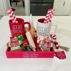 two mugs filled with cookies and candy canes on top of a kitchen counter