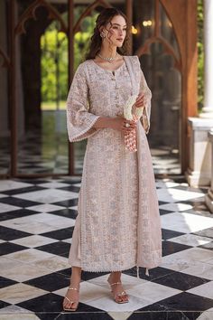 Create a striking statement in Swara this season, featuring a raw silk shalwar and a chikankari embroidered shirt adorned with light sequins, pearl hanging buttons, and milky lace accents on the border and sleeves. The look is complete with a dupatta that showcases four-sided chikankari borders. This is a 3 pc outfit. Lucknavi Suits Design, Chikankari Dress Patterns, Lakhnowi Suits Design, Lukhnowi Suits Design, Roka Outfits, Lucknowi Chikankari Suits, Shirt Kurti, Simple Indian Suits, Pakistani Clothes Online