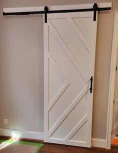 an open sliding door in a room with hardwood flooring and white paint on the walls