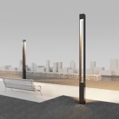 a bench sitting on top of a cement ground next to a tall pole with a light at the end