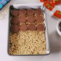 a pan filled with rice and chocolates next to some candy