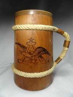 a wooden mug with rope wrapped around the bottom and an eagle on it's side