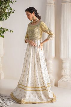 A contemporary Classic - Over a canvas of Pure chikankari chiffon, features a beautiful floral embroidered bodice further enhanced with dabka, sequins, pearls and kundan work. This classy peshwas is paired with gorgeous kamdani work dupatta, making this an absolute favorite for nikkah, engagement & other celebratory festivities Hand crafted tassels & straight pant completes the look of this outfit. Peshwas Fabric: Pure Chiffon Peshwas Length: 60” (customisable, mention in order notes) Sleeve length: 16” Pant Fabric: Khaadi Silk Dupatta Fabric: Georgette Chiffon Color: Ivory & Gold This outfit is fully lined, neck key-hole can be lined on request, mention in order notes. Please refer Size Guide Before selecting size For Customised measurements please select Custom size for an additional 20$ Intricate Embroidered Anarkali Dress In Chanderi, Transitional Anarkali Dress With Resham Embroidery, Raw Silk Anarkali Set With Chikankari Embroidery For Reception, Cream Gown With Resham Embroidery For Festive Occasions, Eid Reception Dress With Chikankari Embroidery, White Silk Choli With Intricate Embroidery, Silk Anarkali Set With Chikankari Embroidery For Reception, Anarkali Organza Dress With Chikankari Embroidery, Silk Choli With Intricate Embroidery For Party