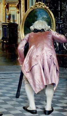 the back of a woman in a pink dress holding a cane and looking into a mirror