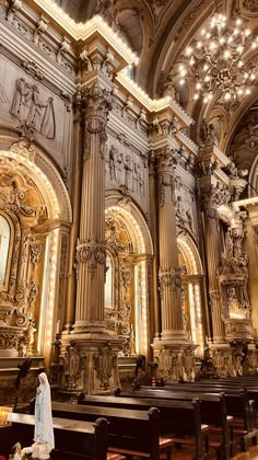 an ornately decorated church with pews and chandeliers