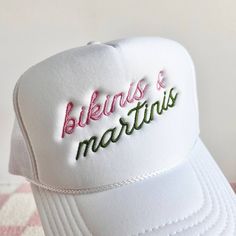 Bikinis & Martinis Embroidered Trucker Hat 100% polyester Foam trucker hat with mesh back, adjustable snap closure and embroidered design. Bach Trucker Hats, Beach Trucker Hat With Embroidered Logo And Curved Brim, Trucker Hat With Embroidered Logo For Beach, White Summer Hat With Embroidered Logo, Summer Vacation Hats With Embroidered Logo, White Trucker Hat For Beach Season, Fitted White Beach Hat, Summer Hats With Embroidered Logo, White Fitted Hat For Beach