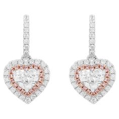 Beautiful Heart shaped Dangling earrings with certified White diamonds and Rare Pink diamonds. Heart Shape White Diamond (GIA Certified) - 0.50 cts Heart Shape White Diamond (GIA Certified) - 0.50 cts Pink diamond - 0.14 cts Round Brilliant cut white diamonds - 0.53 cts 18k Gold HYT Jewelry is a privately owned company headquartered in Hong Kong, with branches in Tokyo, New York, and Bangkok. The company specializes in fine jewelry. It is renowned for an exceptional range of Fancy Color Diamonds and Color Stones (including Colombian Emeralds and Burma Ruby) ranging from rare to the rarest in various hues and color intensities studded in the jewelry with the finest craftsmanship. HYT is committed to producing the finest and exquisite jewelry pieces with sophisticated state-of-the-art techno Pink Diamond Earrings, Gold Diamond Drop Earrings, Argyle Pink Diamonds, Drop Earrings Silver, Pink Diamonds, Drop Design, Color Stones, Colombian Emeralds, Diamond Drops