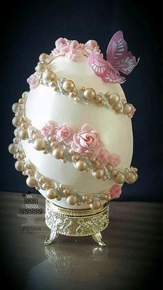 a white cake with pink flowers and butterflies on it's top, sitting on a table