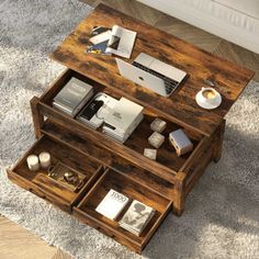 a coffee table that has some books on it and a laptop in the bottom drawer