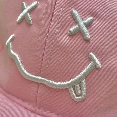 a pink hat with an airplane embroidered on it