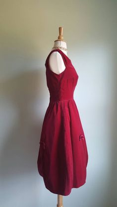 A vintage red: This stunning violet-red velvet 1950s party dress just gets better with time. Gown features a built-in net crinoline and structured interfacing in the skirt for fullness; gathered little cap sleeves; darling satin bows all around, a festive textural contrast to the velvet; and a flattering fitted, princess-seamed bodice. Back metal zip. Era: 1950s Label: No maker tag; there is a custom-order tag Bust: 34/35 inches Waist: 24/25 inches Length from shoulder to hem: 41 inches Vintage Burgundy Dress For Evening, Vintage Burgundy Evening Dress, Burgundy Vintage Evening Dress, Vintage Burgundy Party Dress, Crinoline Skirt, 1950s Party Dresses, Red Party, Formal Party Dress, 50s Dresses