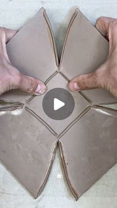 two hands are holding some tiles on the floor