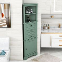 a bathroom with a toilet, sink and green cabinet in front of the bathtub