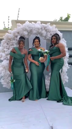 three women in green dresses standing next to each other and posing for a photo together