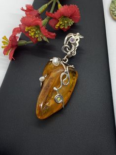 "ARTISAN AMBER GEMSTONE PENDANT Hand-made Sterling Silver. Stones used: Baltic Amber, Pearls, Peridot, Amethyst. Height - 73mm, Width - 30mm. Unique Handcrafted One-of a-kind Design Pendant Each Piece of Jewelry in my Collection is Absolutely One of a Kind! When you start wearing a piece of my jewelry you will fall in love with it more and more each day and feel that good Energy and Love that I pass into it while creating this piece of Art. A piece of Art created for you to be inspired and love Fusion Style Pearl Pendant Jewelry As Gift, Fusion Style Pearl Pendant Jewelry For Gift, Elegant Gemstone Pendant Beads, Elegant Gemstone Pendant, Handmade Elegant Pendant Beads, Gems, And Cabochons, Elegant Freeform Gemstone Jewelry, Handmade Elegant Round Pendant Gemstones, Handmade Pendant Gemstones For Formal Occasions, Artisan Beads And Cabochons Pendant For Gift