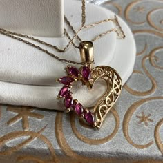 "Up for sale is this vintage estate 10 karat solid yellow gold reversible heart pendant necklace.  The heart pendant is reversible.  One side features seven baguette prong-set stones - reddish pink in color - possibly rubies.  The reverse side features five tiny round clear stones set in an attractive white gold setting.  The necklace chain is a 10 karat delicate pendant chain measuring 20\" long.  The pendant measures 3/4\" wide by 5/8\" high.  The inside of the pendant bail is marked 10K.  The Heart Cut Jewelry For Valentine's Day Collectibles, Collectible Heart Cut Jewelry For Valentine's Day, Heart Cut Collectible Jewelry For Valentine's Day, Collectible 14k Gold Heart-shaped Jewelry, Collectible Heart-shaped Gemstone Jewelry, Antique Hallmark Jewelry For Valentine's Day, Collectible Pendant Jewelry For Valentine's Day, Collectible Heart-shaped Jewelry For Valentine's Day, Valentine's Day Heart Charm Jewelry Collectible