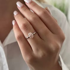 a woman's hand with a diamond ring on it