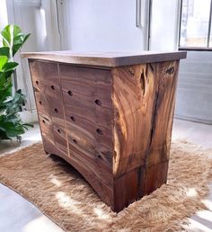 a large wooden chest sitting on top of a carpeted floor next to a potted plant