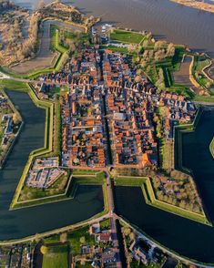 an aerial view of a city next to a body of water