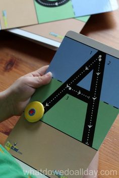 a child is playing with a magnetic board that has a map on it and a yellow button in the middle