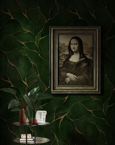 a painting hanging on the wall next to a table with a potted plant in front of it