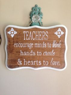 there is a sign on the wall that says teachers encourages minds to think hands to create & hearts to love