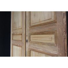 two wooden doors with black walls in the background