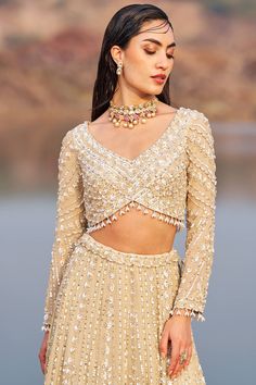 This gorgeous gold hand-crafted embellished lehenga is paired with an embroidered sweetheart neck blouse in georgette. The padded blouse ensures a comfortable fit and is secured with a back hook closure. Completing the ensemble is a hand-worked net dupatta, adding an extra touch of elegance to your outfit. Sweetheart Neck Blouse, Embellished Lehenga, Lehenga And Blouse, Gold Lehenga, Padded Blouse, Indian Wedding Wear, Gold Hand, Net Dupatta, Fashion App